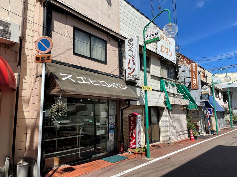 “スエヒロード”の黄色いサイン。松本さんの発案で、美原商店街全体の末広がりを願って街灯の新調時に作られた。