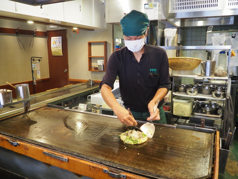 生地にさまざまな食材を乗せ、見事なてこさばきで焼く