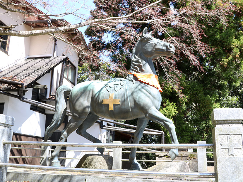 参道入口の鳥居を抜けた先に神馬が４体出てくる。腹部にあるマークは能勢妙見山の紋章。