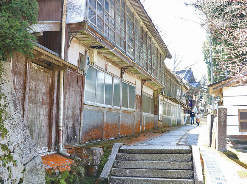 元々宿だった建物が並ぶ境内の通り道。扉のサビつきも経年劣化による味わいになる。